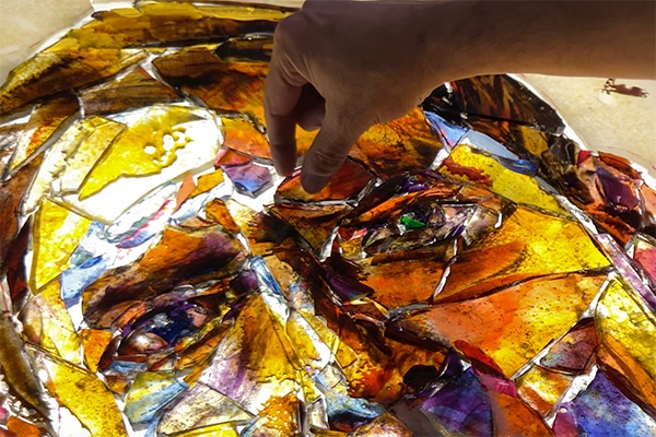 Tim Carey building an image from pieces of broken glass