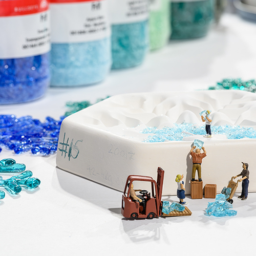 little figures loading frit into a mold